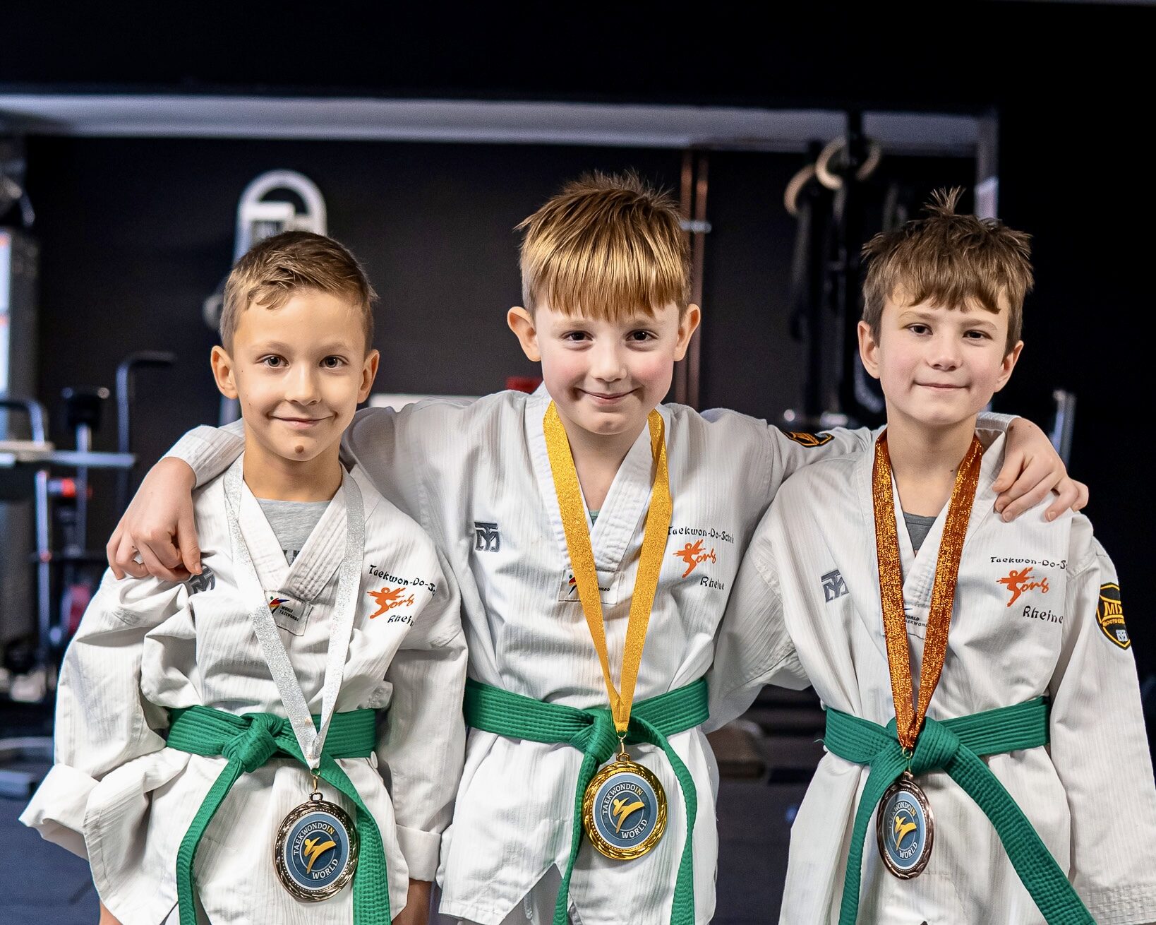 Drei Jungen stehen bei der Siegerehrung bei einem Taekwondo-Turnier
